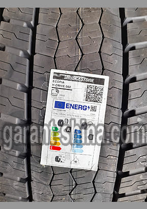 Bridgestone Ecopia H-Drive 002 (приводная) 315/70 R22.5 154/150L 18PR - Фото протектора с этикеткой вблизи